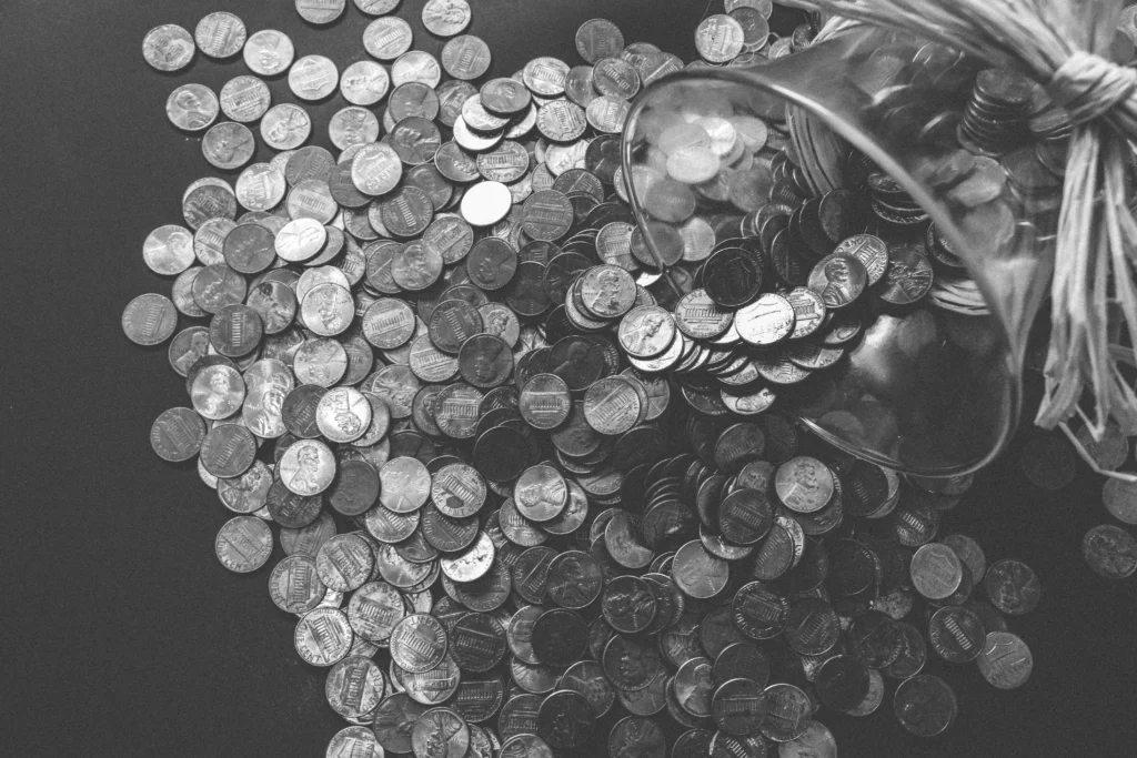 collection of poured coins from glass bowl